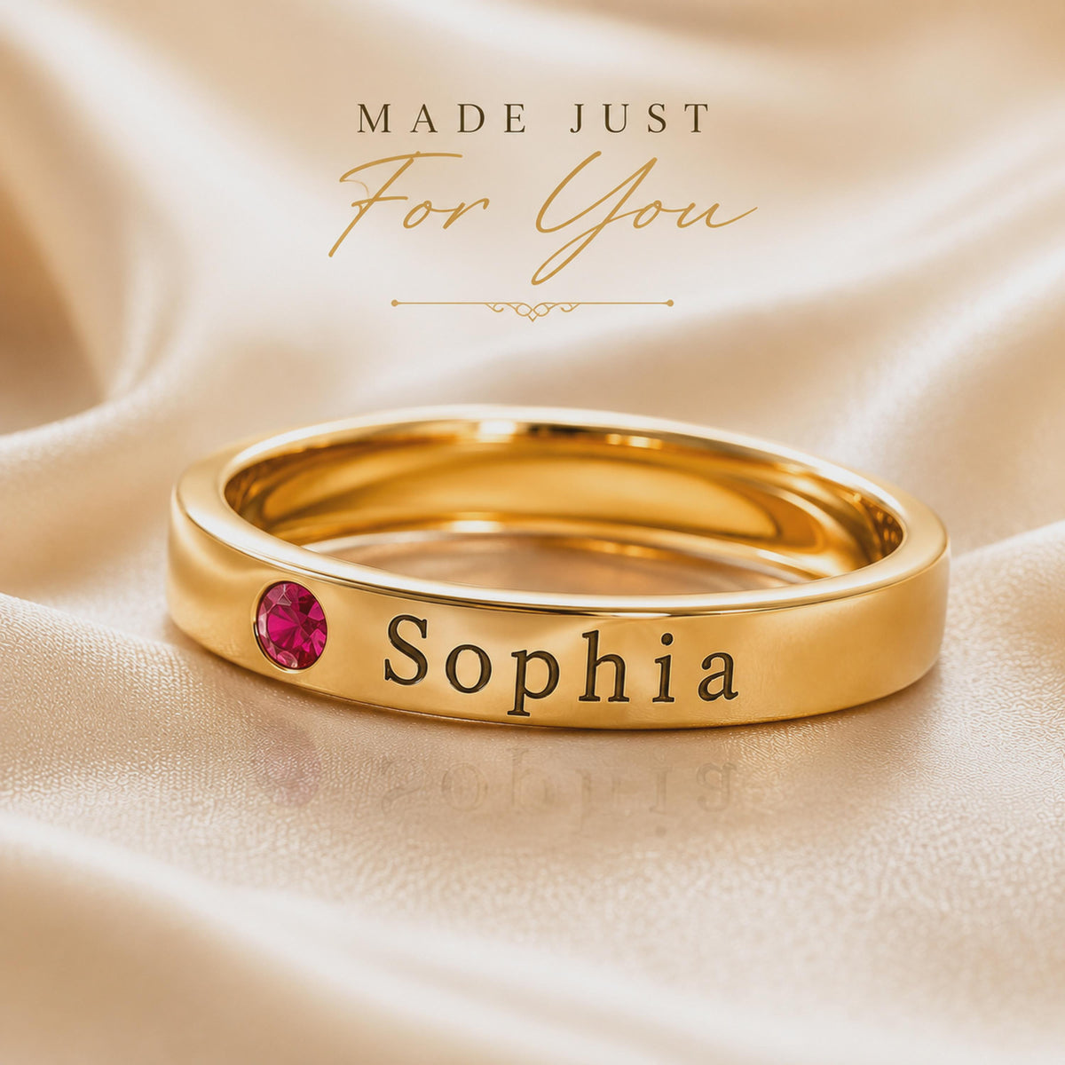 Gold tone name ring engraved Sophia with a July red birthstone color