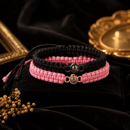 Black and pink braided projection bracelets on black velvet