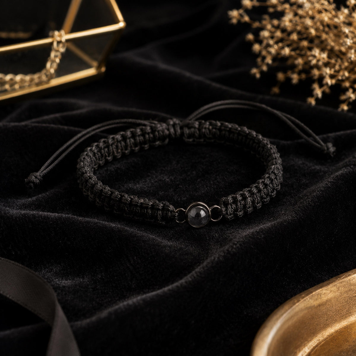Black projection bracelet with a dark round charm on black velvet