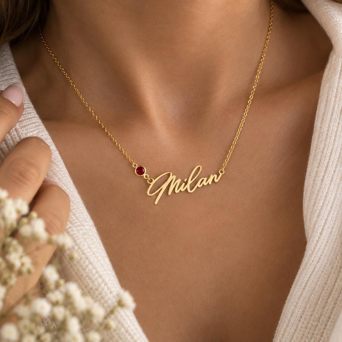 Gold tone name necklace worn on the neck
