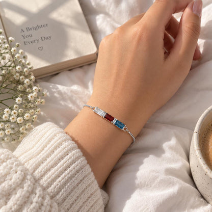Gold tone baguette birthstone bracelet worn on the wrist, close up