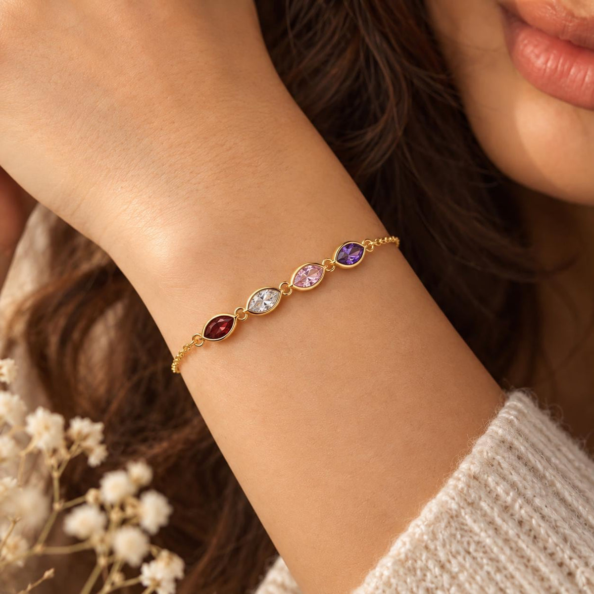 Gold tone leaf birthstone bracelet worn on the wrist
