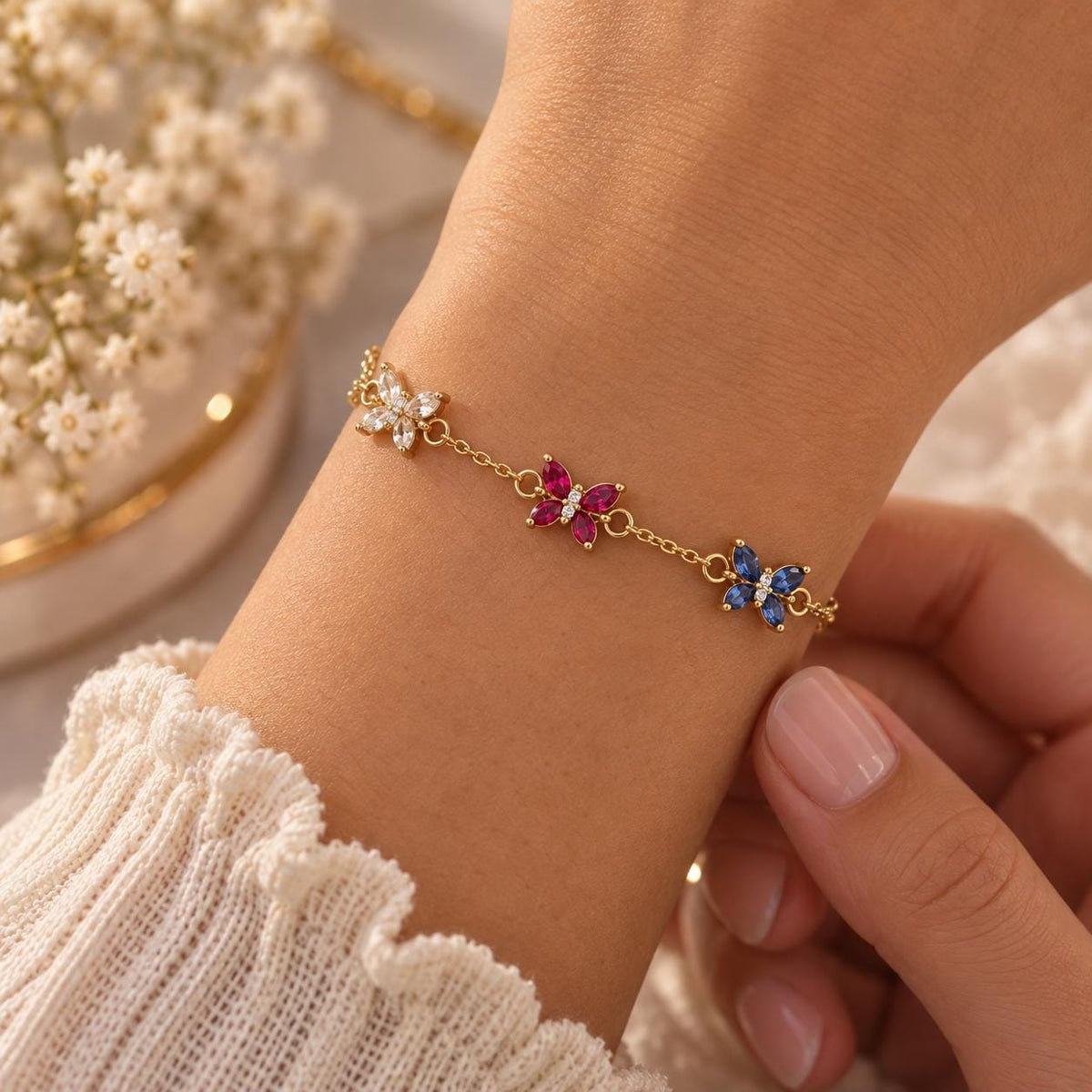 Gold tone butterfly birthstone bracelet on the wrist, close up