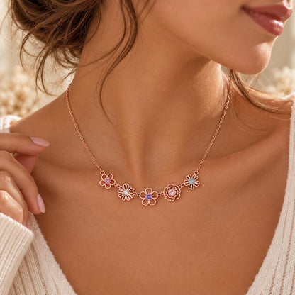 Rose gold tone family birth flower necklace worn on the neck