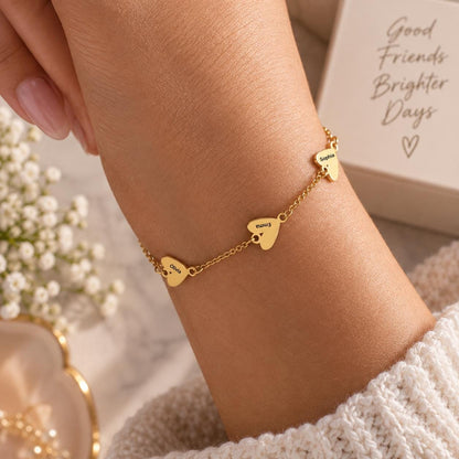 Gold tone heart name bracelet worn on the wrist