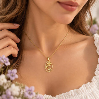 Gold tone birth flower necklace with an oval flower pendant worn on the neck