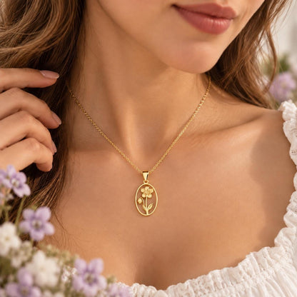 Gold tone birth flower necklace with an oval flower pendant worn on the neck