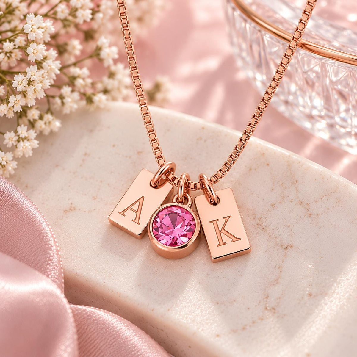 Rose gold tone initial tag necklace with a pink stone