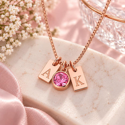 Rose gold tone initial tag necklace with a pink stone