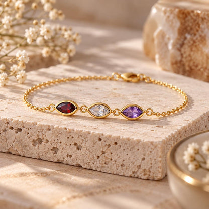 Gold tone leaf birthstone bracelet on a stand