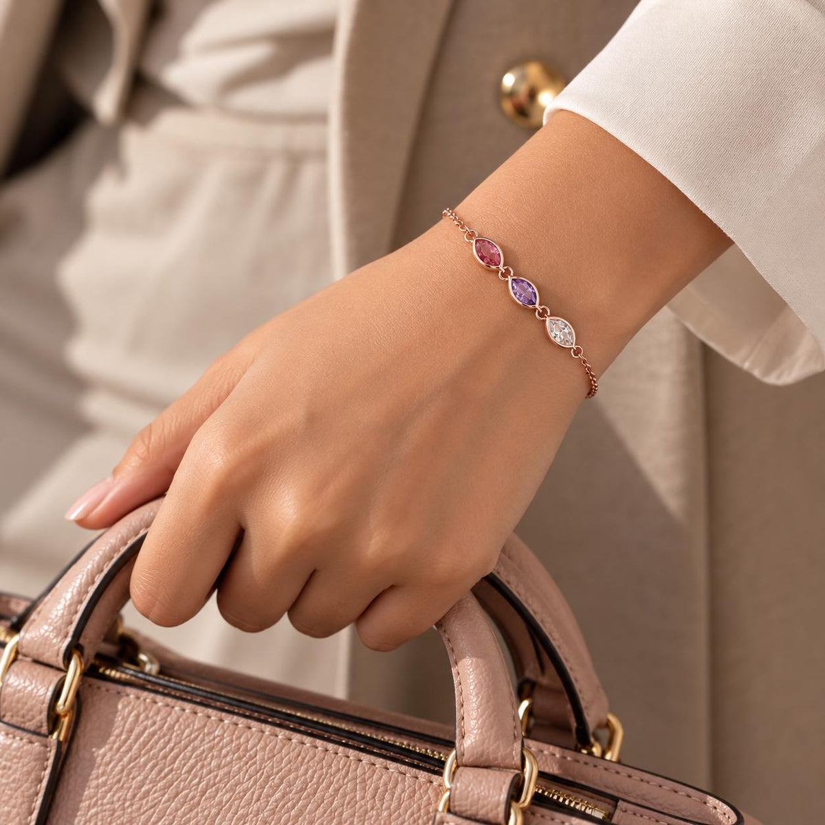 Leaf birthstone bracelet worn on the wrist with a handbag