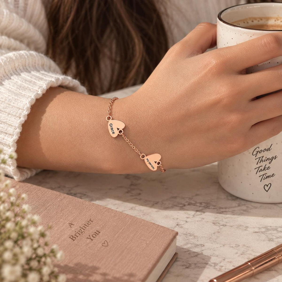 Rose gold tone heart name bracelet worn on the wrist