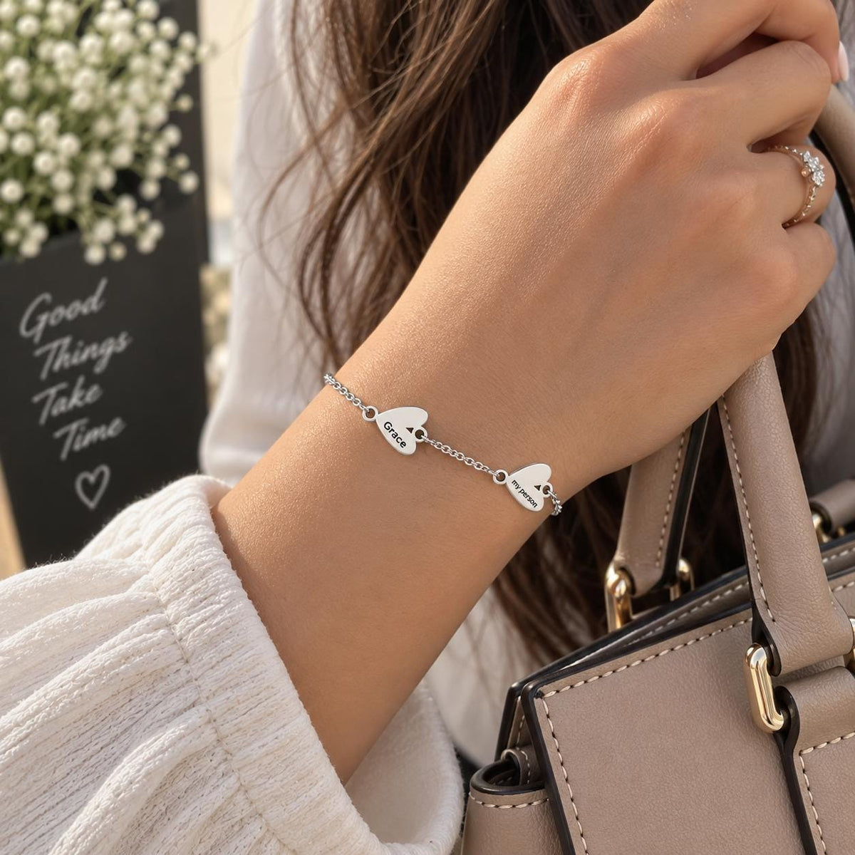 Silver tone heart name bracelet worn on the wrist