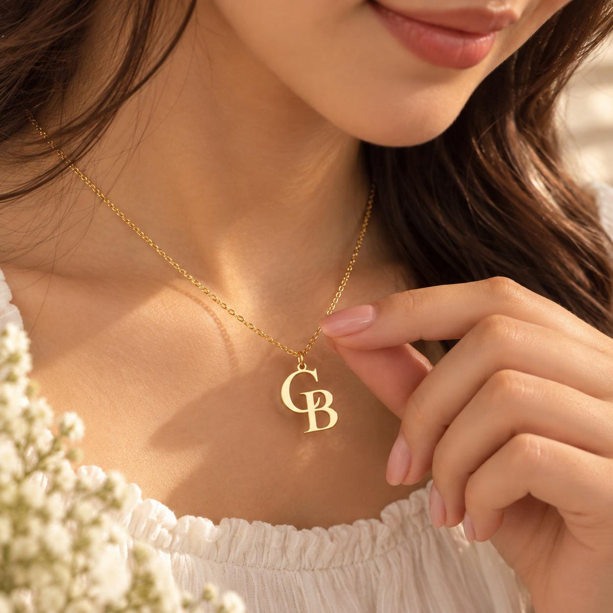 Gold tone double initial necklace with the letters C and B worn on the neck