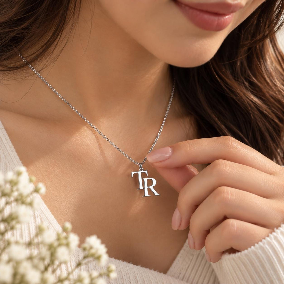 Silver tone double initial necklace worn on the neck